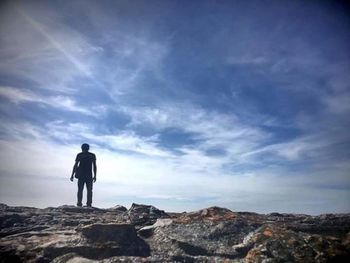 Rear view of man standing on rock