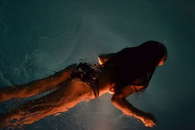 High angle view of woman swimming in pool at night