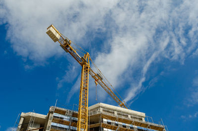 Modern construction finishing facade of house with glass window panels, scaffolding crane