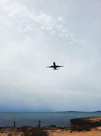 Scenic view of sea against sky and airplane