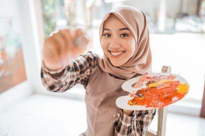 Portrait of smiling young woman having food