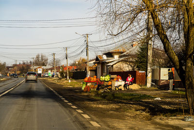 People walking on road in city against sky