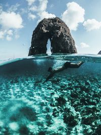 Rock formation in sea against sky