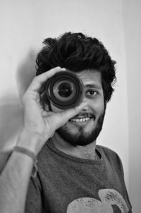 Portrait of man photographing against wall