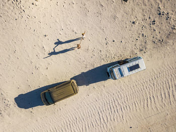 Aerial view of friends and cars on land