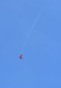 Low angle view of airshow flying against clear sky