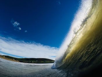 Wave splashing in sea against sky