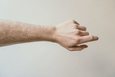 Cropped hand of man against beige background