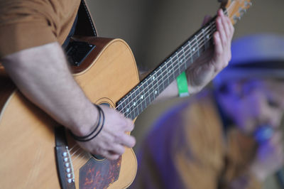 Midsection of man playing guitar