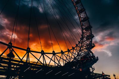 Low angle view of silhouette ferris wheel against sky