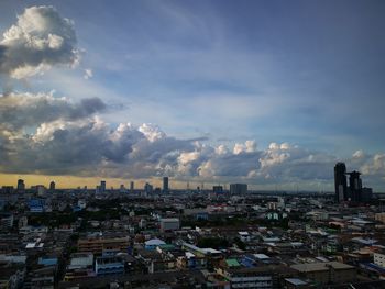 Aerial view of buildings in city against sky