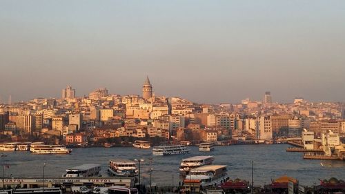 Boats in sea with city in background