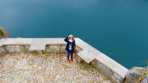 Full length of woman standing against blue sky