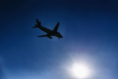 Low angle view of airplane against blue sky