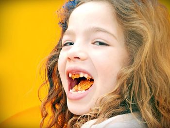 Close-up portrait of smiling girl eating food