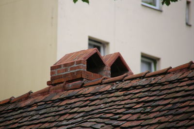 Low angle view of house roof against building