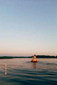 Person in sea against clear sky