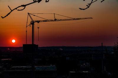 Silhouette of communications tower against sky during sunset