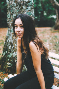 Portrait of young woman sitting on bench