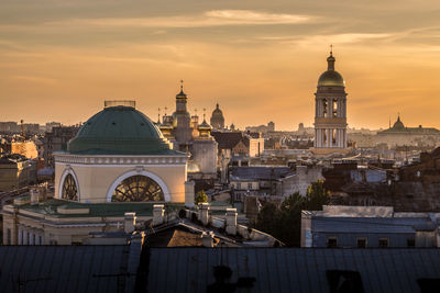 Buildings in city against sky during sunset