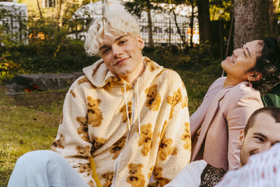 Portrait of smiling gay man with friends during party in back yard