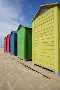 Beach huts by buildings against sky