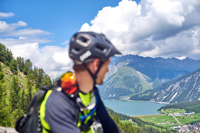 Man with arms outstretched against mountain range