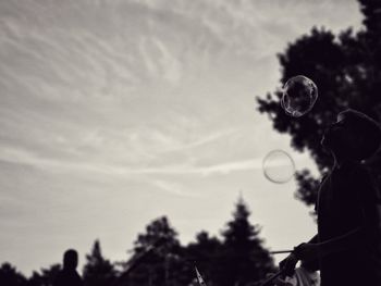 Low angle view of woman bubbles against sky