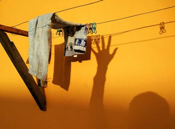 Low angle view of clothes line against yellow wall