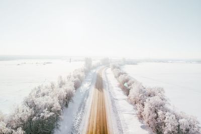 Panoramic view of road by sea against clear sky during winter