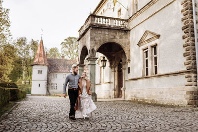 Rear view of man and woman standing outside building