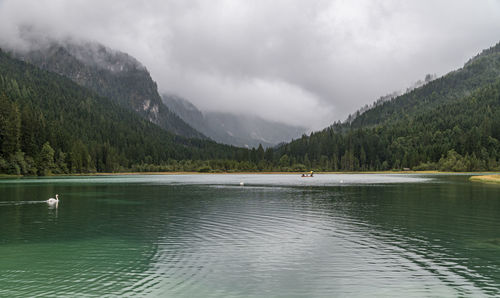 Scenic view of lake by mountains against sky