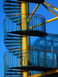 Low angle view of spiral staircase against clear blue sky