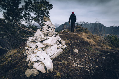 Rear view of man standing on mountain against sky