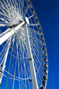 Low angle view of ferris wheel against blue sky