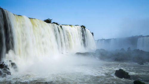 Scenic view of waterfall against sky