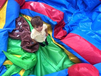 Portrait of boy wearing multi colored umbrella