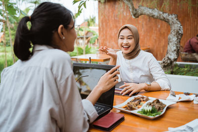 Side view of young woman using mobile phone