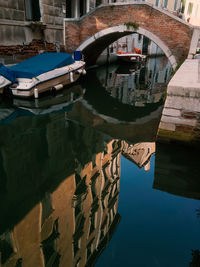 Boats moored in canal against sky