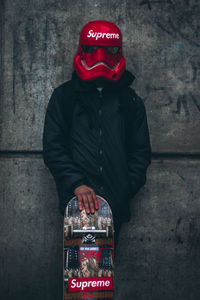 Man standing against red wall