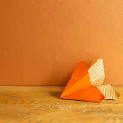 Umbrella on paper against orange wall