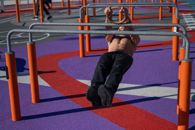 Low section of man standing on railing