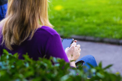 Rear view of woman sitting on field