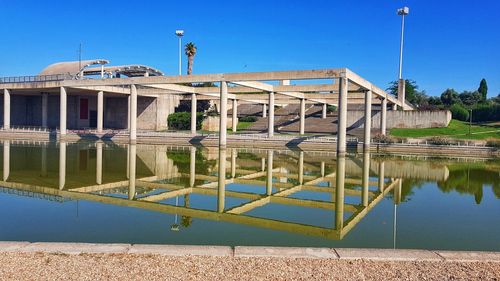 Reflection of building in lake against blue sky