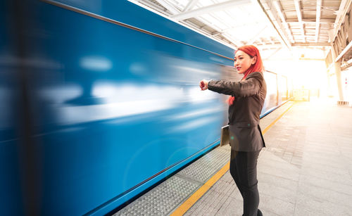 Full length of woman standing on escalator