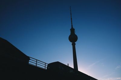 Low angle view of communications tower against blue sky