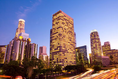 Low angle view of illuminated buildings against sky in city