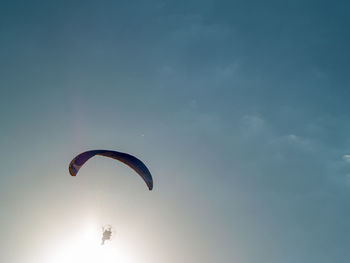 Low angle view of person paragliding against sky