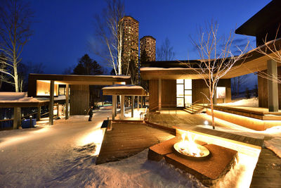 Houses by swimming pool against sky at night