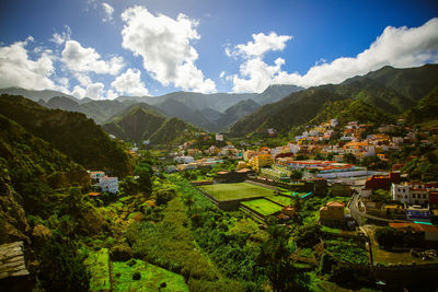 Scenic view of townscape and mountains against sky